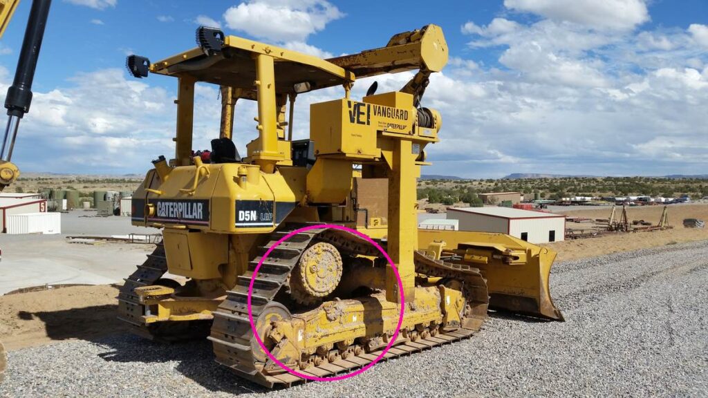 Caterpillar D5N LGP pipelayer dozer from behind with the undercarriage circled, sprocket and track rollers visible | magenta circle on sprocket, rollers and track