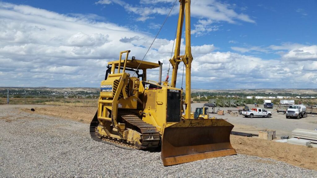 aterpillar dozer fitted with a Midwestern M540c pipelayer sideboom, front three-quarter view in a New Mexico yard