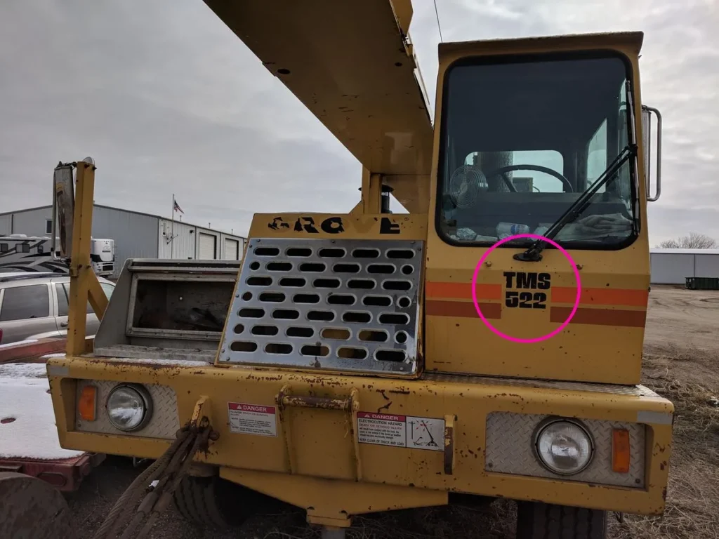 Front of a Grove TMS522 truck crane with the TMS 522 model badge on the cab door circled